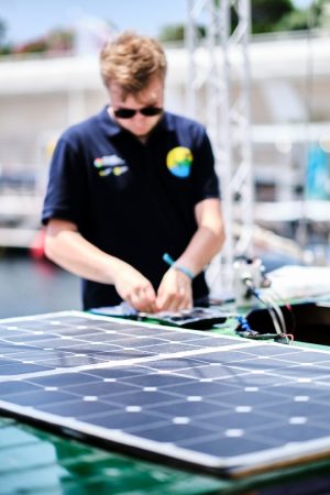 a young student working on his boat's solar panel